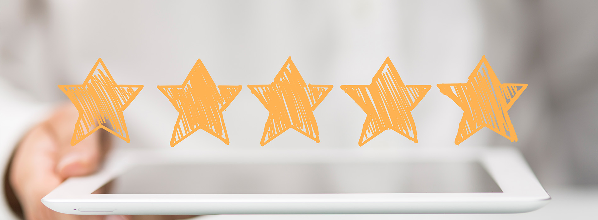 The image shows a hand holding a tablet with a row of five orange star ratings on a white background.
